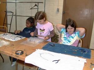 Laying out their necklaces and choosing beads.